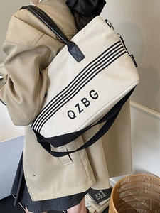 Large striped canvas tote bag in beige with black straps for daily commute or campus