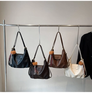 Detail of multi-colored retro shoulder bags with bear charms and textured leather finish