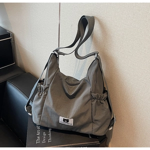 Vista dettagliata della borsa tote in nylon grigio con tasca a coulisse su libro di design