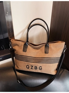 Brown canvas tote bag with black leather straps and detachable shoulder strap for women