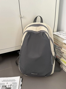 Minimalist beige and charcoal grey color-block backpack for travel and daily use