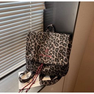 Close-up of leopard print backpack with red embroidery on the canvas flap cover