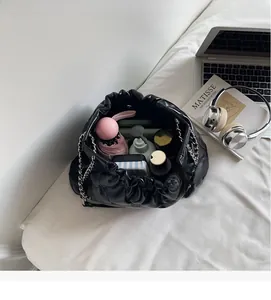 Intérieur spacieux du sac seau noir matelassé avec accessoires du quotidien dedans