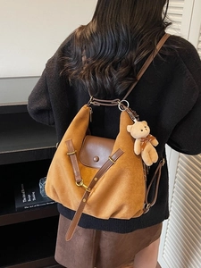 Large leopard print tote bag with bear pendant shown on a model in a library
