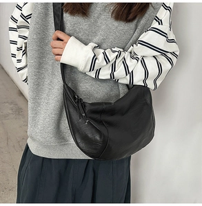 Détail du grand sac bandoulière croissant noir avec fermeture éclair sur le mannequin