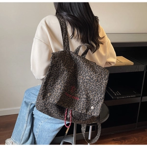 Detail of vintage leopard print canvas backpack with red easy embroidery and drawstring