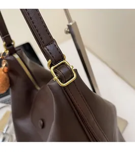 Macro detail of high-quality gold metallic hardware and dark brown faux leather shoulder strap