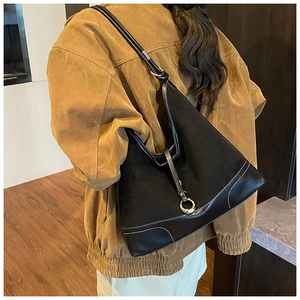 Detail view of black vintage tote bag with contrast white stitching and metal ring buckle