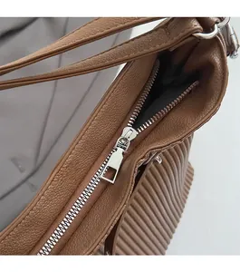 Close-up of litchi texture leather tote with smooth metal zipper and side gusset detail