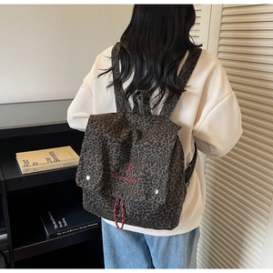 Detailed back view of leopard print backpack featuring red take it easy embroidery
