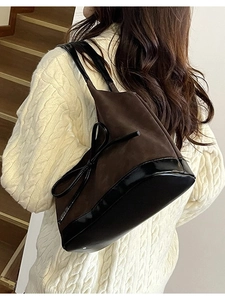 Retro brown bucket bag with a black bow detail and patent leather patchwork design