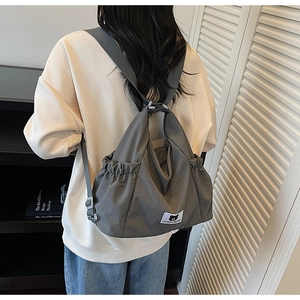 Detail of dark grey adjustable strap and bear logo patch on large canvas tote bag