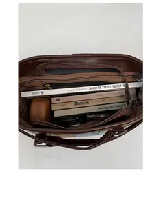 Top-down view of spacious dark brown leather tote bag interior with striped lining