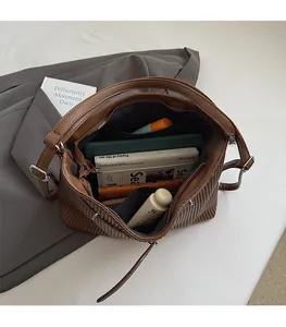 Detailed interior of a dark brown pleated shoulder bag showing spacious storage compartment