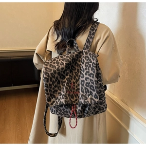Close-up of leopard print backpack with metal buckles and take it easy embroidery detail