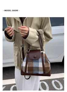 Detail of vintage plaid wool handbag featuring brown leather trim and retro round buckle