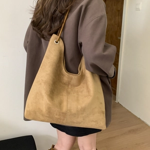 Side view of a large khaki suede tote bag showing soft texture and stitching detail