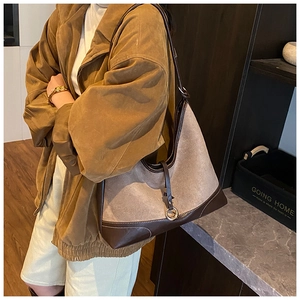 Detail of taupe felt tote bag with brown leather trim and gold metal ring buckle