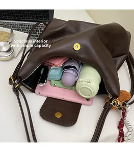 Top view of spacious interior of dark brown leather tote bag with various essentials
