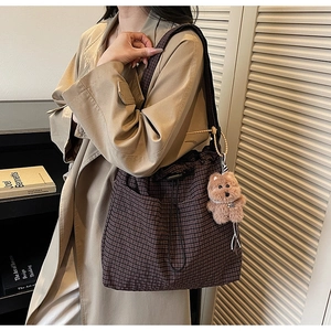 Brown plaid canvas tote bag detail with drawstring closure and cute bear plush charm