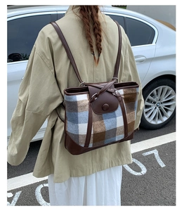 Detail of vintage plaid tweed backpack with brown leather straps and flap closure