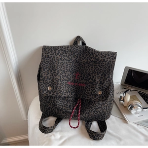 Detail of leopard print backpack with red 'take it easy' embroidery and drawstring closure