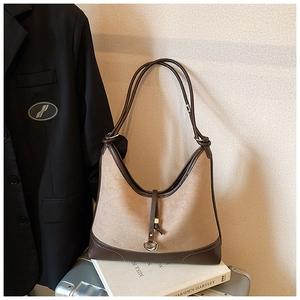 Detail of retro hobo bag with leather patchwork on silver suitcase and books