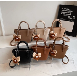 Litchi pattern leather handbags in multiple colors with plush doll charms and straps
