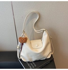 Detail of cream PU leather shoulder bag with BAGS FASHION logo and plush bear charm