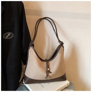 Detail of vintage tote bag featuring brown faux suede and leather contrast panels