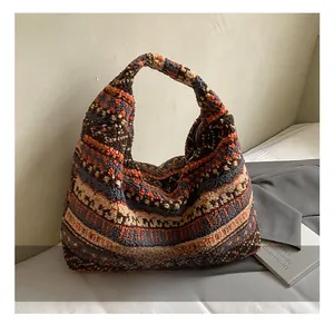 Detailed close-up of plush tote bag featuring colorful ethnic striped pattern and metal zipper