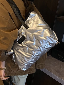 Metallic silver quilted tote bag with black leather straps and glossy finish