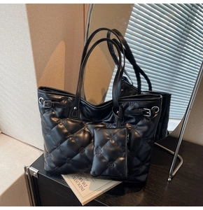 Détail du sac cabas matelassé noir avec motif gaufré et boucle latérale argentée chic