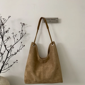 Detail of retro large brown suede hobo tote bag texture with metal grommet strap