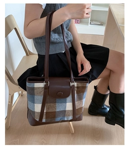 Classic retro plaid tote bag with brown leather details shown in a lifestyle setting