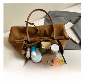 Interior view of large brown suede tote bag showing storage capacity for electronics