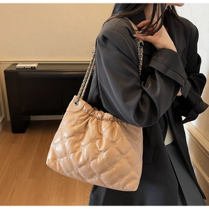 Détail du sac seau matelassé beige avec motif gaufré et ouverture à fronces stylée