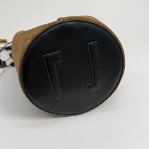 Detailed close-up of a leopard bucket bag's bottom with smooth black leather patches