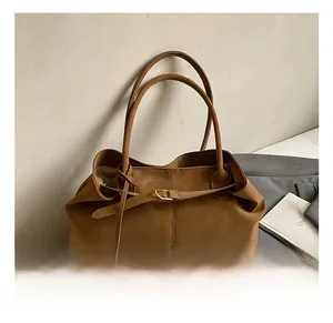 Detailed view of large vintage brown oil-wax leather tote with golden buckle and slim handles