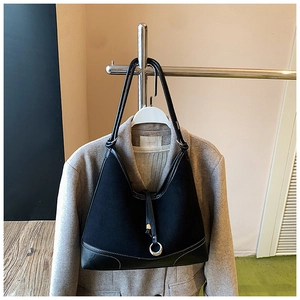 Detail of black tote bag with silver ring buckle on grey coat hanger for daily commute