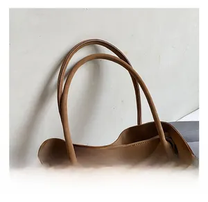 Detail of caramel oil wax leather tote bag showing comfortable handle and reinforced stitching