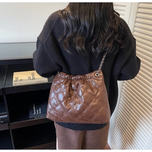 Vue de dos du sac seau matelassé marron porté à l'épaule par un mannequin