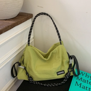 Detail of avocado green nylon tote bag featuring rope handles and fashion brand label