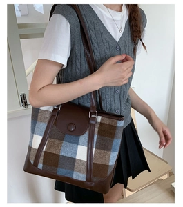 Detail view of large capacity vintage plaid tote bag with brown leather trim and button