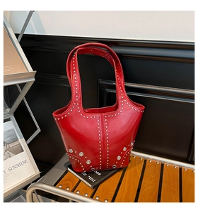 Dettaglio della borsa a spalla rossa lucida con rivetti argentati e grandi occhielli in metallo