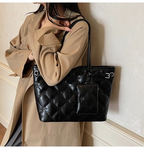 Détail du sac cabas noir matelassé avec motifs floraux et pochette supplémentaire