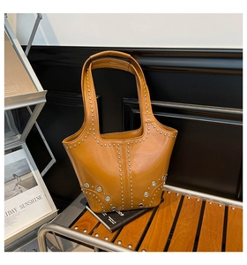 Dettaglio della borsa tote in pelle color cuoio con borchie e anelli in metallo argento