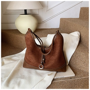 Detailed close-up of brown suede tote bag featuring silver metal ring and leather trim