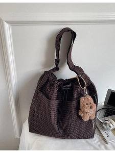 Minimalist dark brown checkered bucket bag with drawstring closure and teddy bear charm