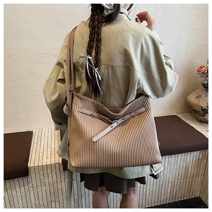 Close-up of a large pleated shoulder bag in camel brown with elegant buckle detail